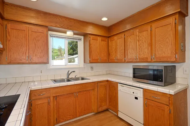 a kitchen with stainless steel appliances granite countertop white cabinets a sink and a oven