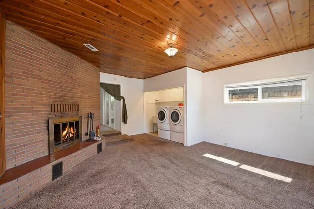 a view of an empty room with a fireplace and a window