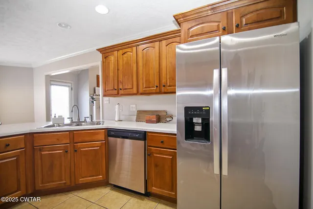 a kitchen with stainless steel appliances granite countertop a refrigerator and a sink