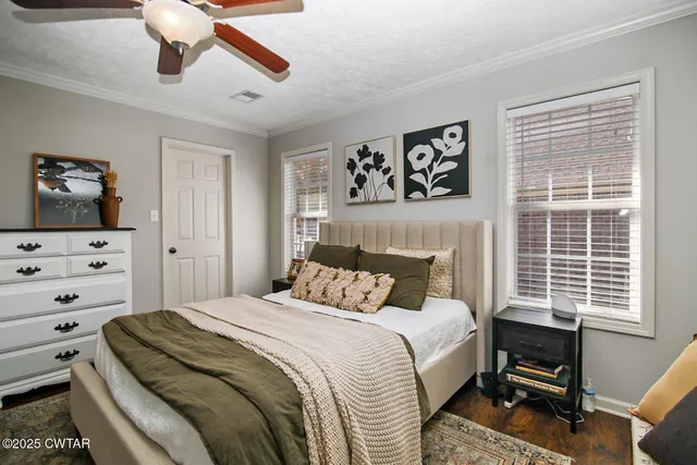 a bedroom with a bed a dresser next to a window