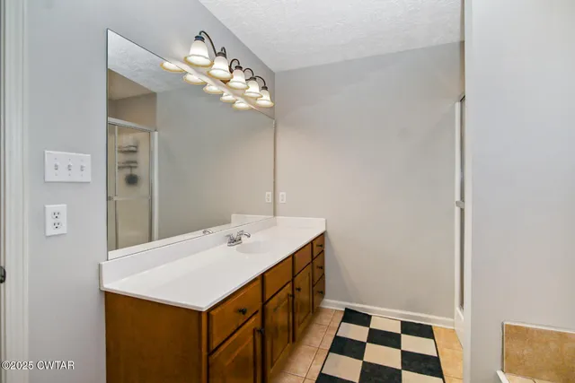 a bathroom with a sink a light fixture and a mirror
