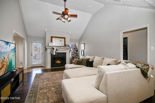 a living room with furniture a flat screen tv and a fireplace