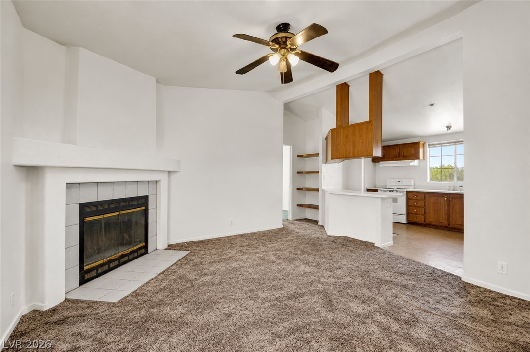 4361 Maple Road Pahrump, NV 89048 - Photo 8 of 35 Warm and inviting living space with a classic fireplace and a well-appointed kitchen view.