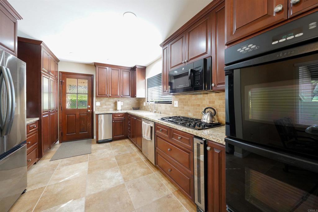341 Pile Street Ramona, CA 92065 - Photo 11 of 50 a kitchen with stainless steel appliances granite countertop a stove refrigerator and cabinets