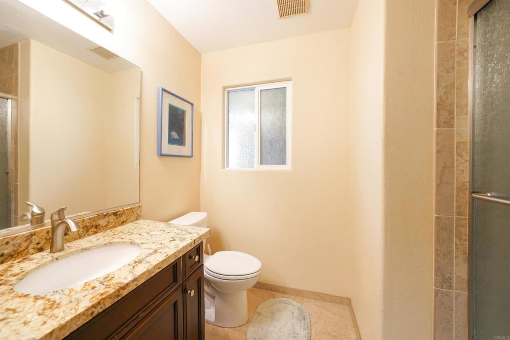 341 Pile Street Ramona, CA 92065 - Photo 32 of 50 a bathroom with a granite countertop sink a toilet and a mirror