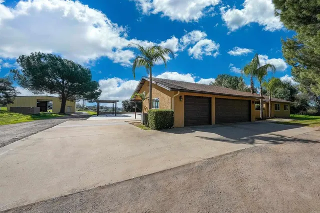 a front view of a house with a yard and trees