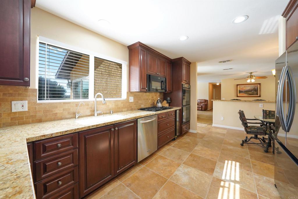 341 Pile Street Ramona, CA 92065 - Photo 10 of 50 a large kitchen with a large counter top space a sink stainless steel appliances and cabinets
