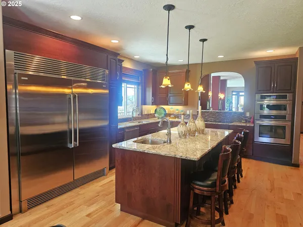a kitchen with kitchen island granite countertop wooden cabinets and stainless steel appliances