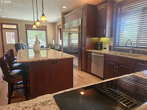 a kitchen with kitchen island granite countertop a sink cabinets and wooden floor