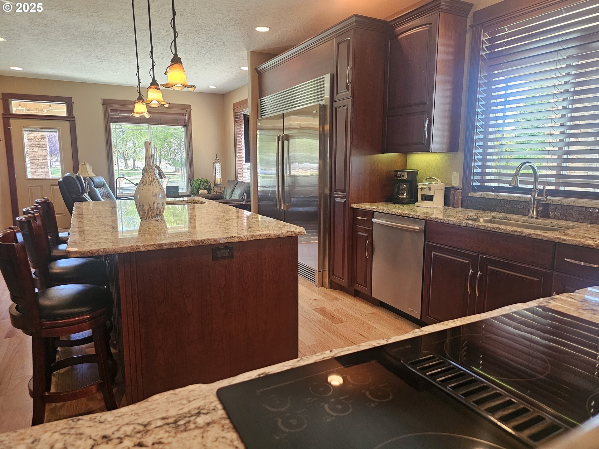 6481 Southwest Wren Lane Culver, OR 97734 - Photo 15 of 44 a kitchen with kitchen island granite countertop a sink cabinets and wooden floor
