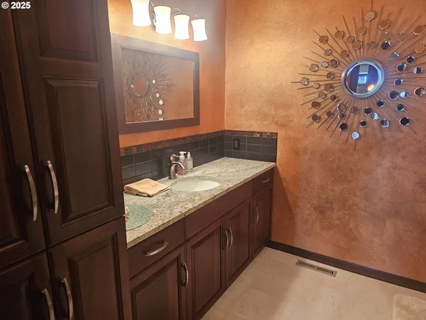 a bathroom with a granite countertop sink a mirror and a shower