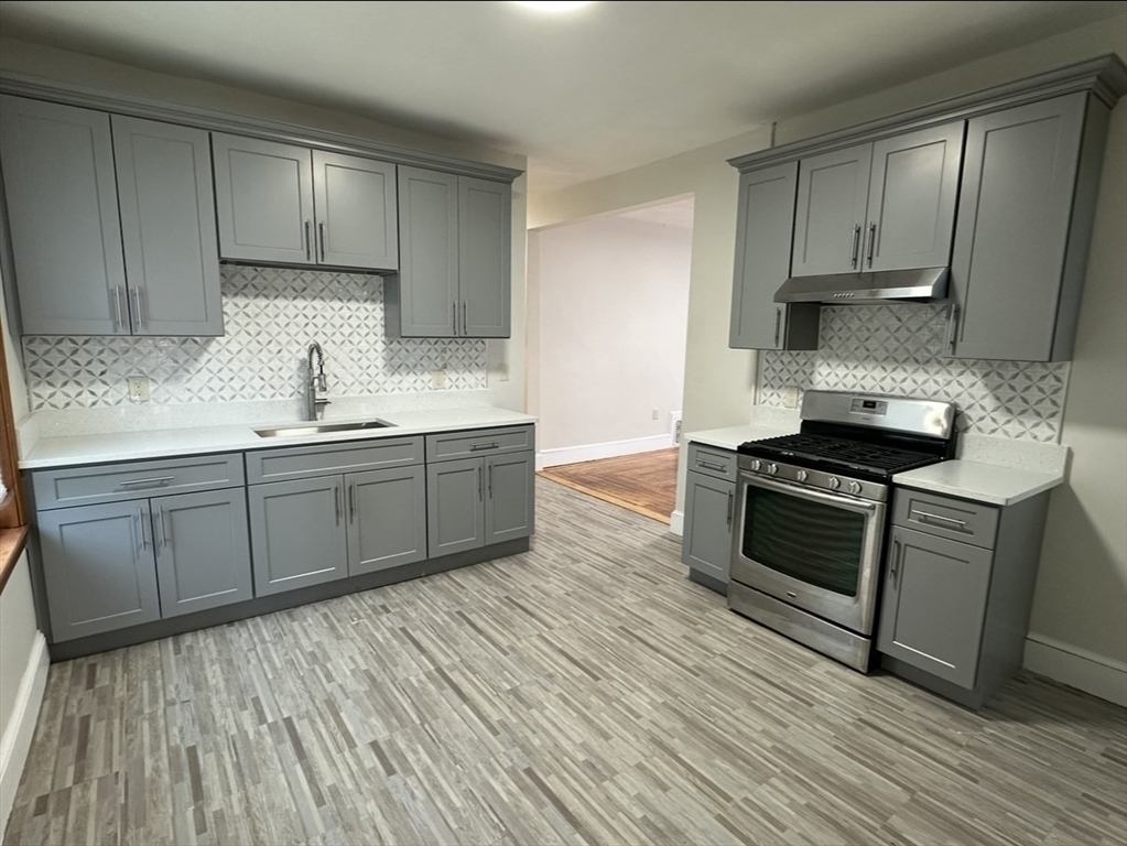 a kitchen with stainless steel appliances granite countertop a stove a sink and a refrigerator