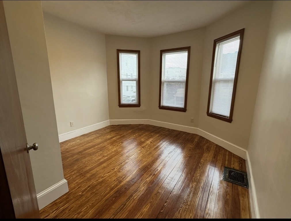11 Tebroc Street, Unit 2 Boston, MA 02122 - Photo 12 of 17 a view of an empty room with wooden floor and a window