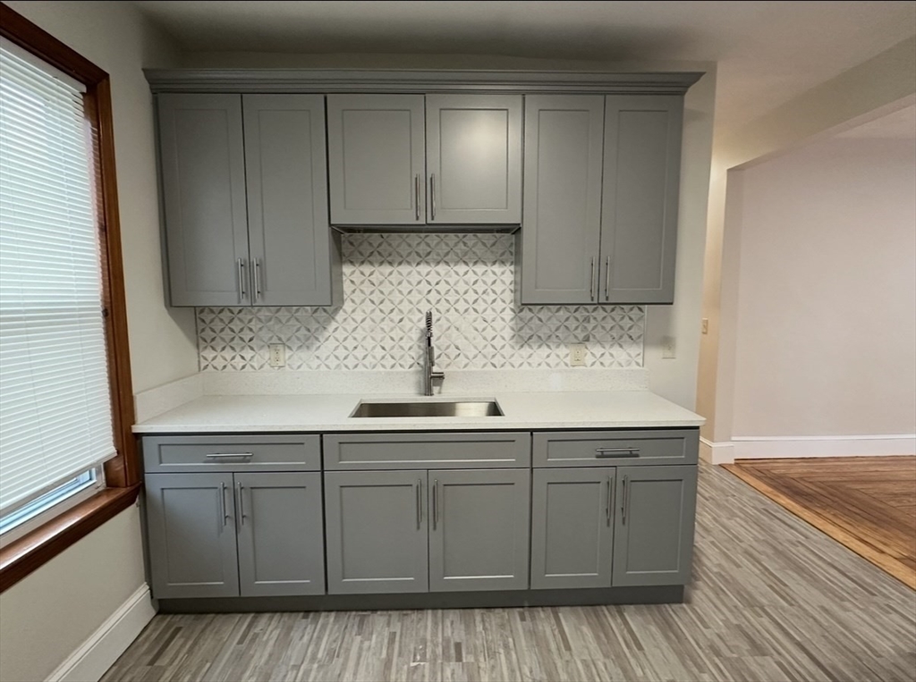 11 Tebroc Street, Unit 2 Boston, MA 02122 - Photo 2 of 17 a kitchen with stainless steel appliances granite countertop a sink and wooden cabinets