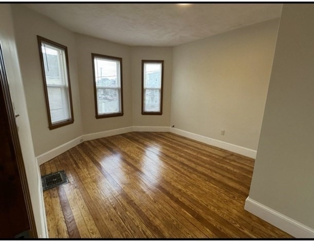 11 Tebroc Street, Unit 2 Boston, MA 02122 - Photo 3 of 17 a view of an empty room with wooden floor and a window
