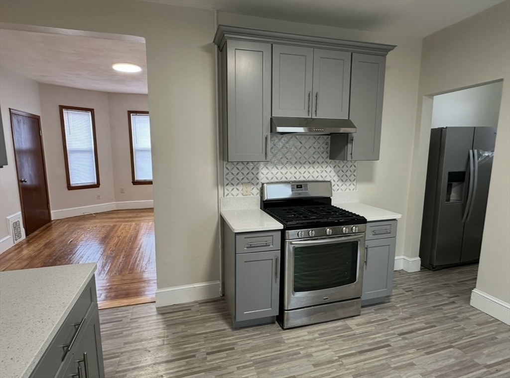 11 Tebroc Street, Unit 2 Boston, MA 02122 - Photo 4 of 17 a kitchen with stainless steel appliances granite countertop a stove and a refrigerator