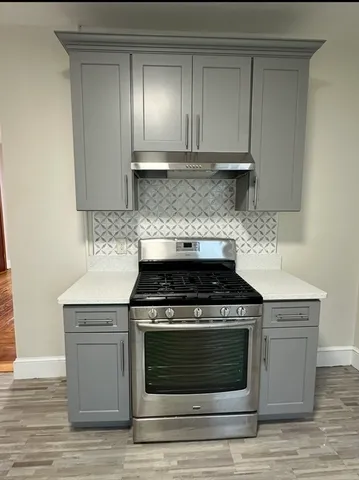 a kitchen with a stove and white cabinets