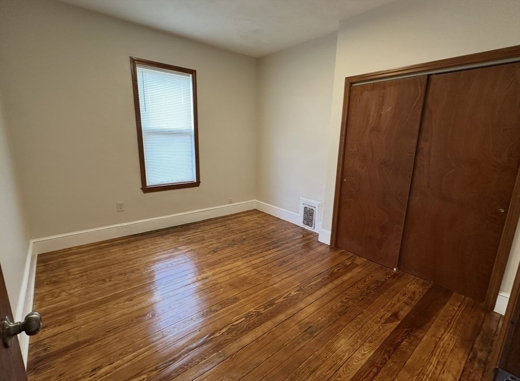 11 Tebroc Street, Unit 2 Boston, MA 02122 - Photo 10 of 17 a view of an empty room with wooden floor and a window