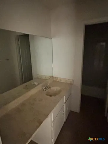 a bathroom with a granite countertop sink and vanity