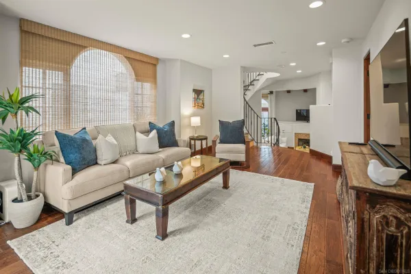 a living room with furniture a wooden floor and a large window