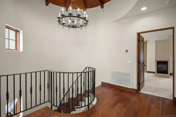 a view of hallway with wooden floor and chandelier