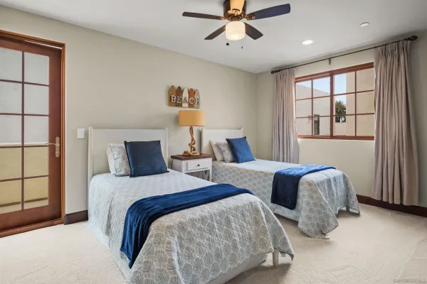 a bedroom with two beds and painting on the wall