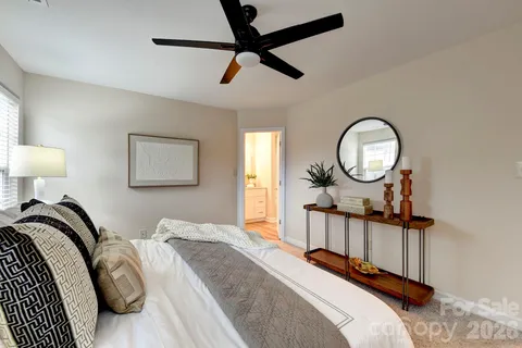 a bedroom with a bed a mirror and paintings on the wall