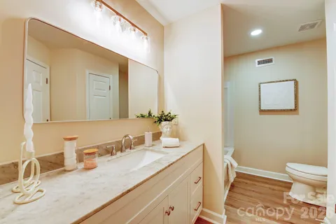 a bathroom with a granite countertop sink a toilet and a mirror