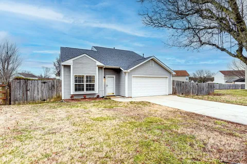 a view of a house with a yard and large tree