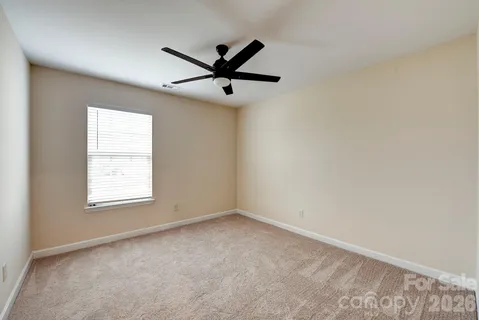 an empty room with a window and a fan