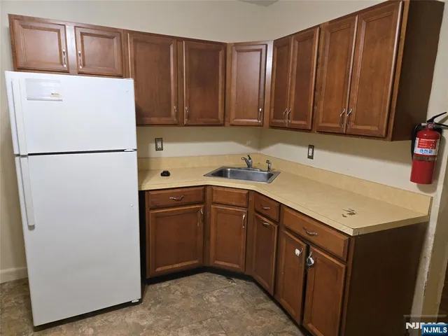 a kitchen with a refrigerator sink and cabinets