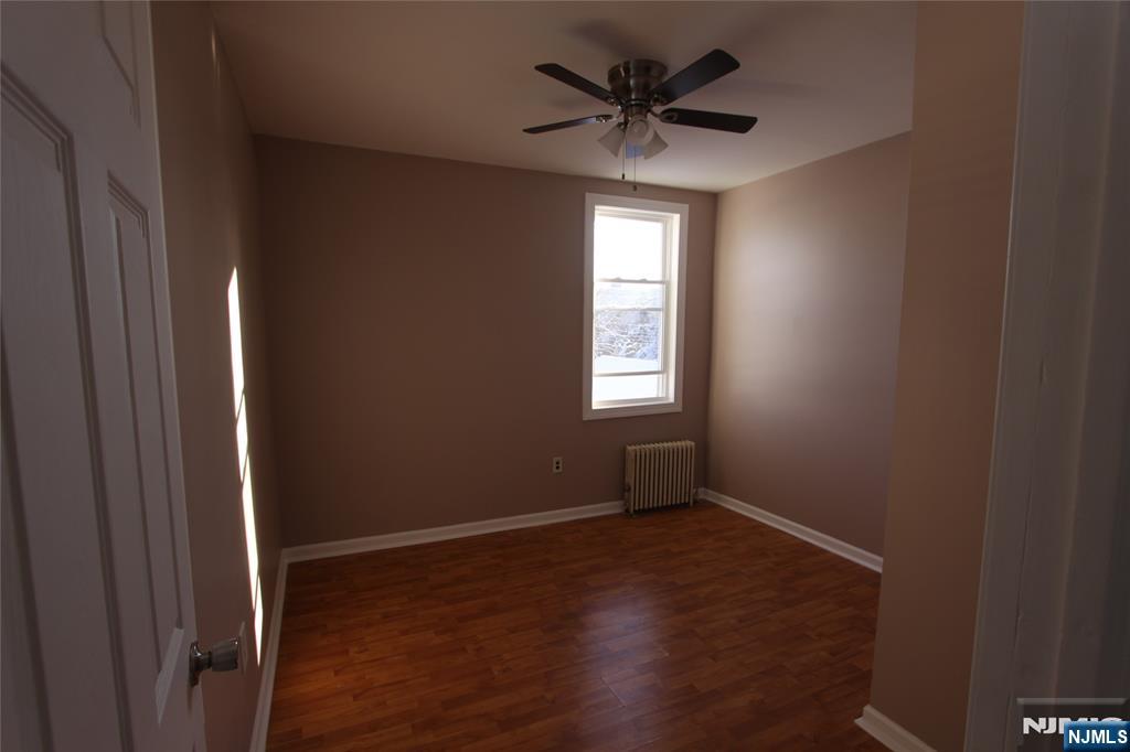 10 Orchard Street, Unit 2 Elmwood Park, NJ 07407 - Photo 2 of 12 an empty room with wooden floor and windows
