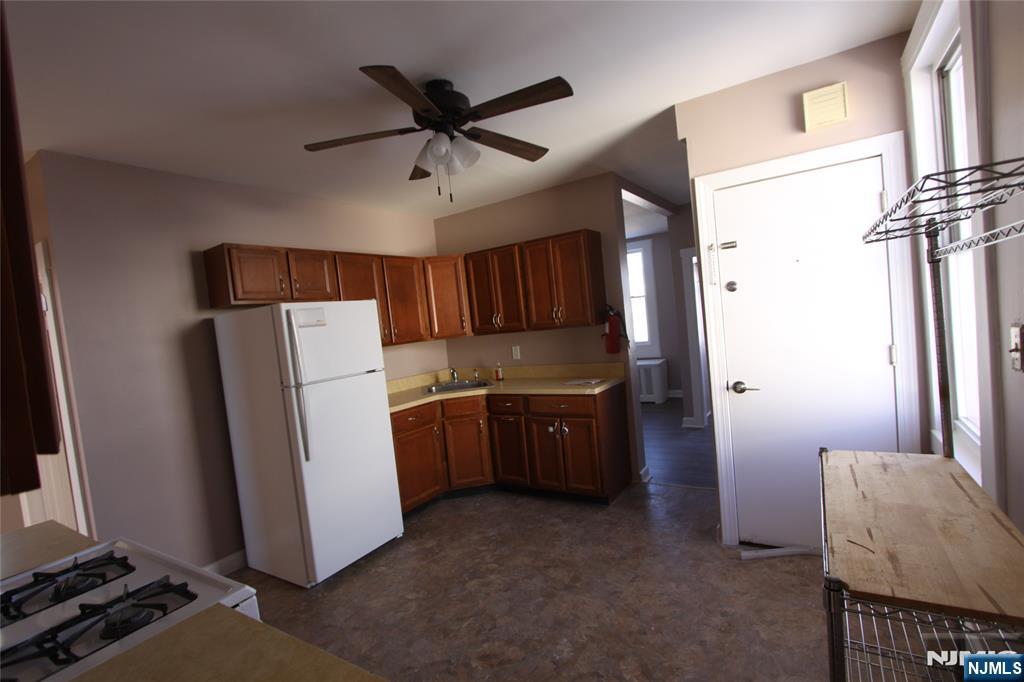 10 Orchard Street, Unit 2 Elmwood Park, NJ 07407 - Photo 4 of 12 a kitchen with stainless steel appliances a refrigerator and a stove top oven