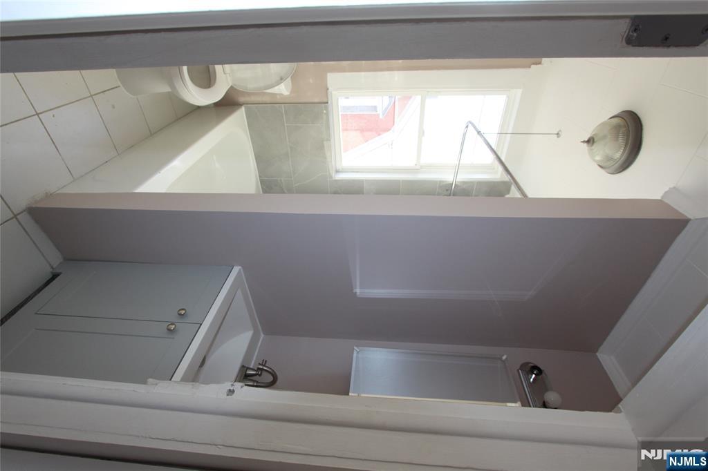 10 Orchard Street, Unit 2 Elmwood Park, NJ 07407 - Photo 8 of 12 a bathroom with a bathtub and sink