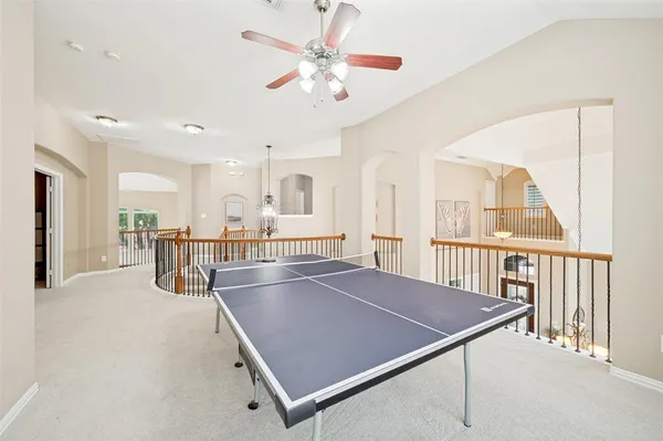 a living room with a table tennis table and a chandelier