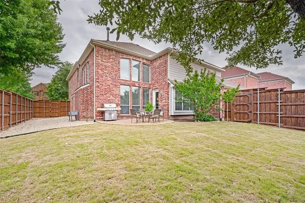 a view of a house with a yard and basketball court
