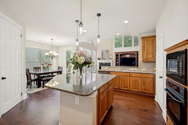 a kitchen with stainless steel appliances granite countertop a sink a stove and a wooden floors