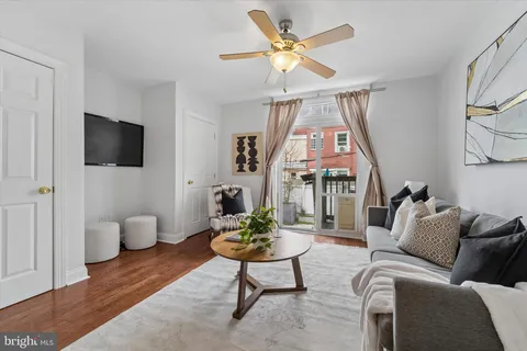 a living room with furniture a flat screen tv and a window
