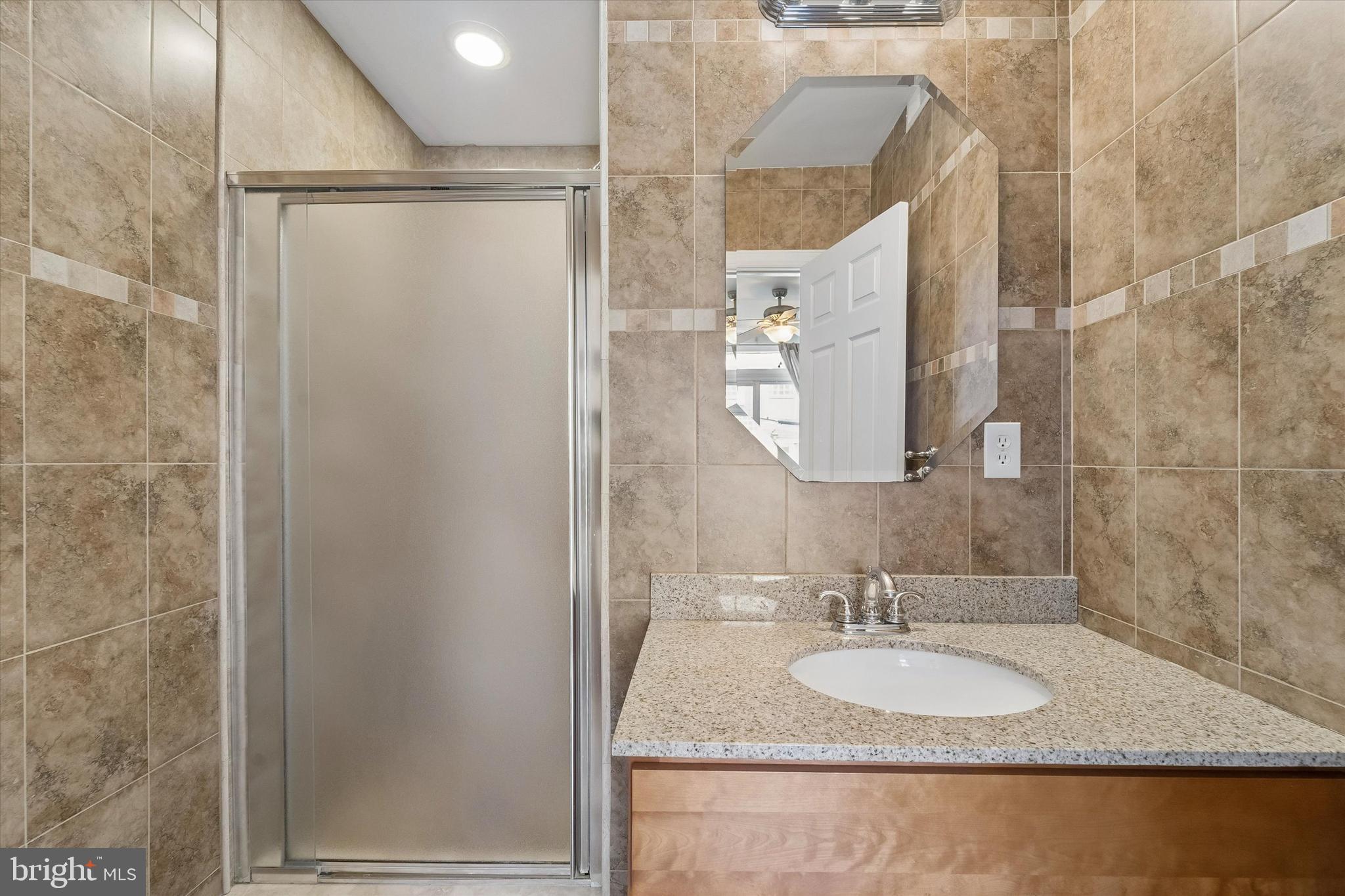 2001 Carpenter Street, Unit B Philadelphia, PA 19146 - Photo 21 of 31 a bathroom with a granite countertop sink and a mirror
