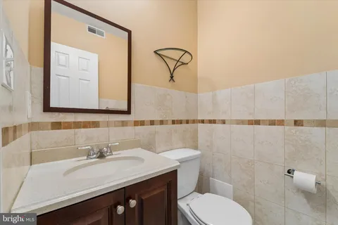 a bathroom with a sink vanity mirror and toilet