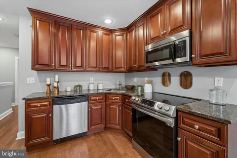 a kitchen with stainless steel appliances granite countertop a stove and a microwave