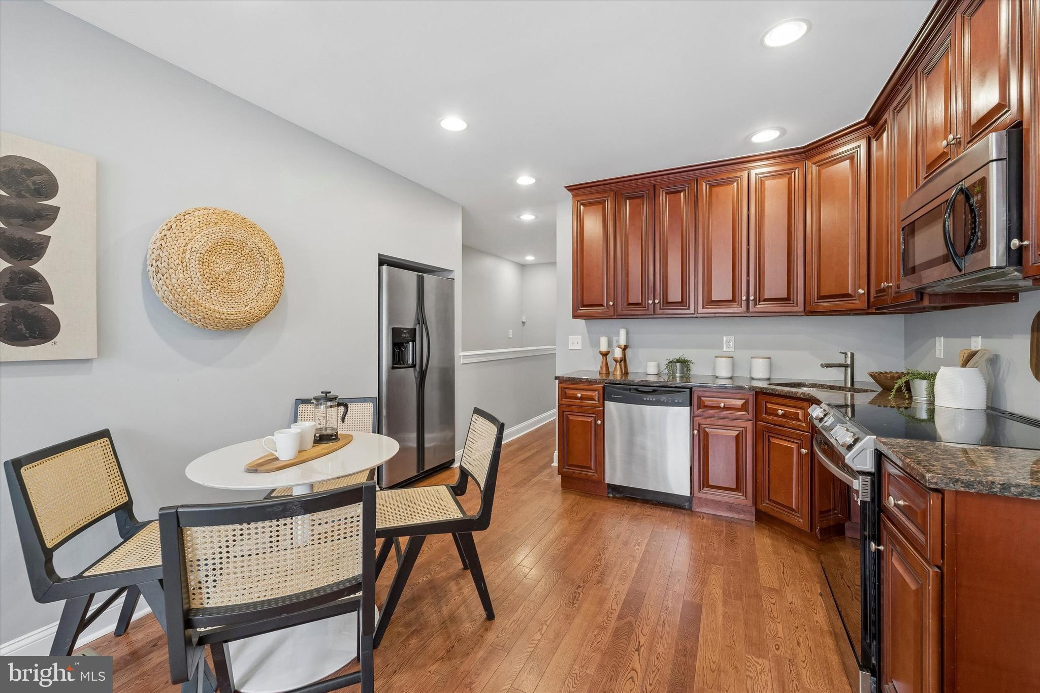 2001 Carpenter Street, Unit B Philadelphia, PA 19146 - Photo 9 of 31 a kitchen with stainless steel appliances granite countertop a stove top oven a dining table and chairs with wooden floor