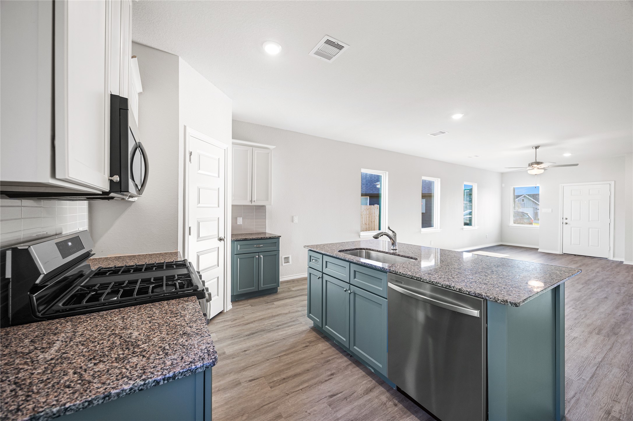 25799 John Wayne Court Splendora, TX 77372 - Photo 12 of 28 a kitchen with stainless steel appliances granite countertop a stove a sink and a refrigerator