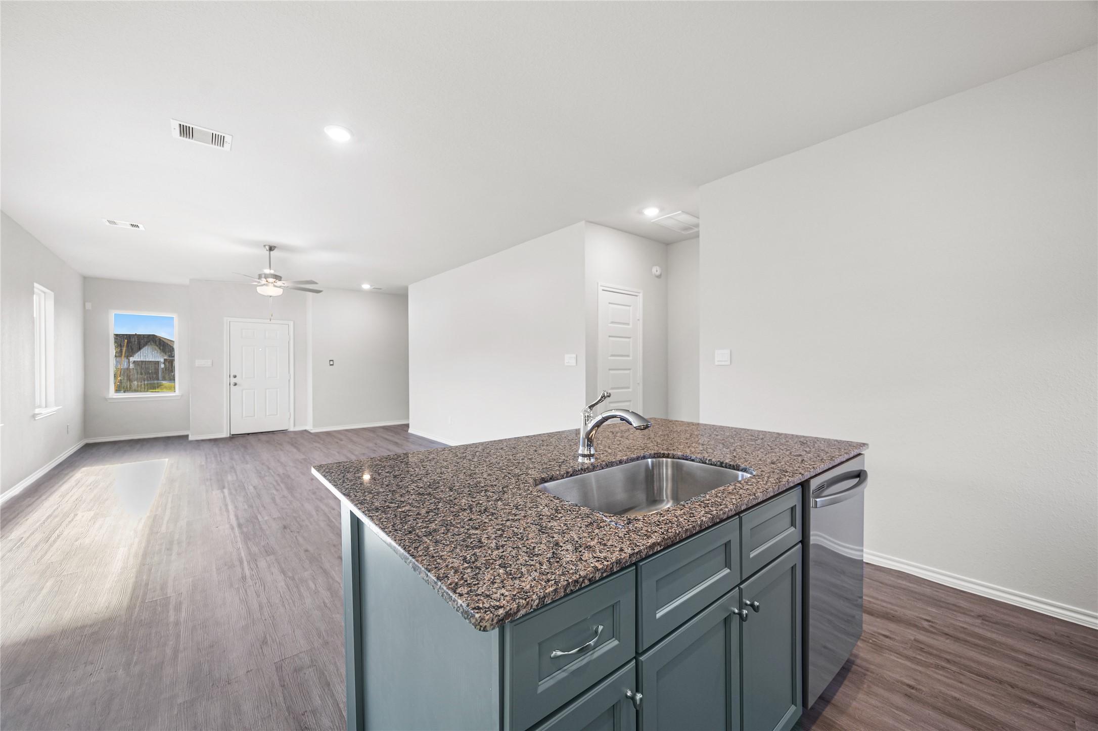 25799 John Wayne Court Splendora, TX 77372 - Photo 15 of 28 a kitchen with a granite countertop sink and wooden floor