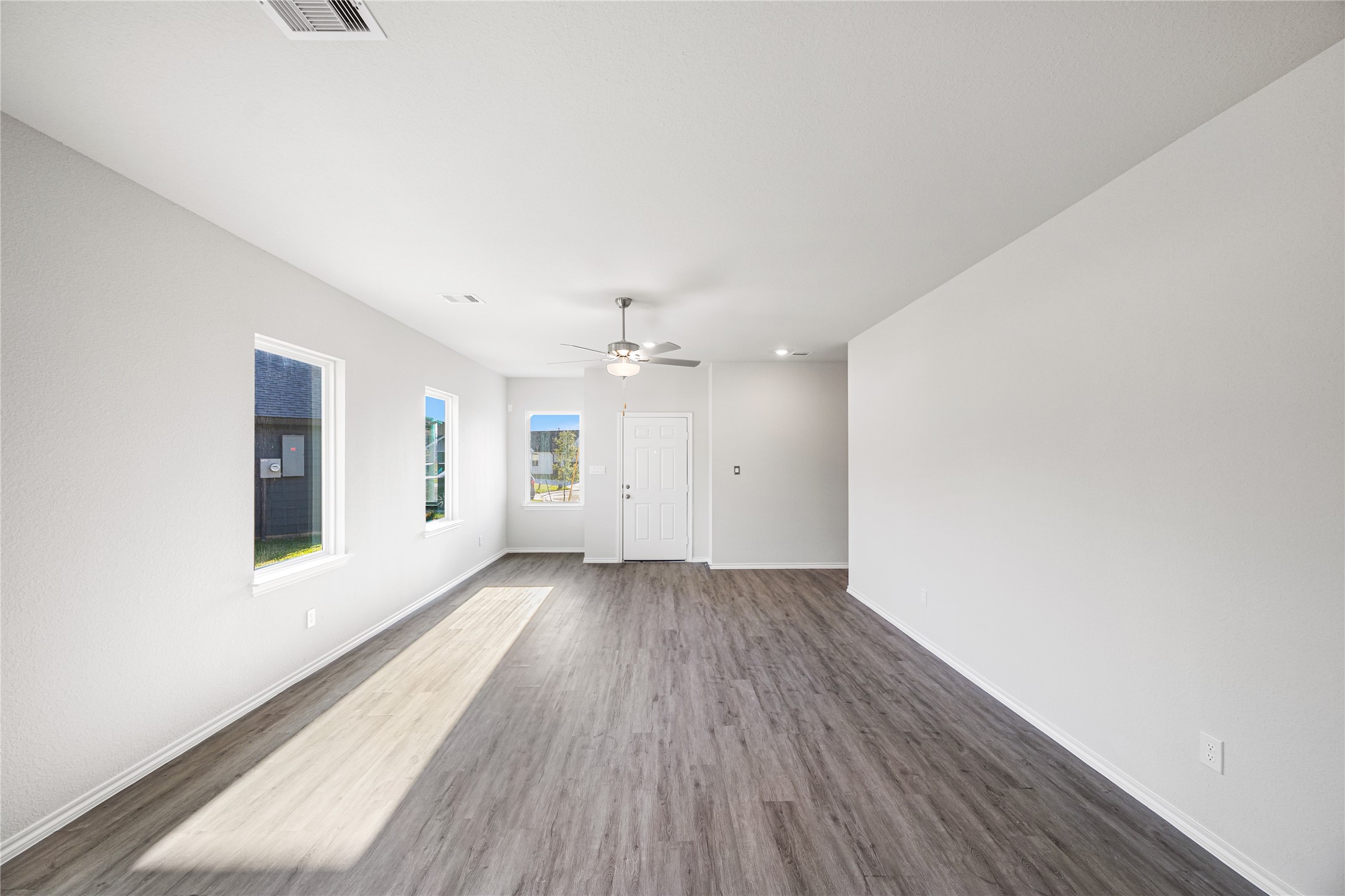 25799 John Wayne Court Splendora, TX 77372 - Photo 7 of 28 an empty room with wooden floor and windows