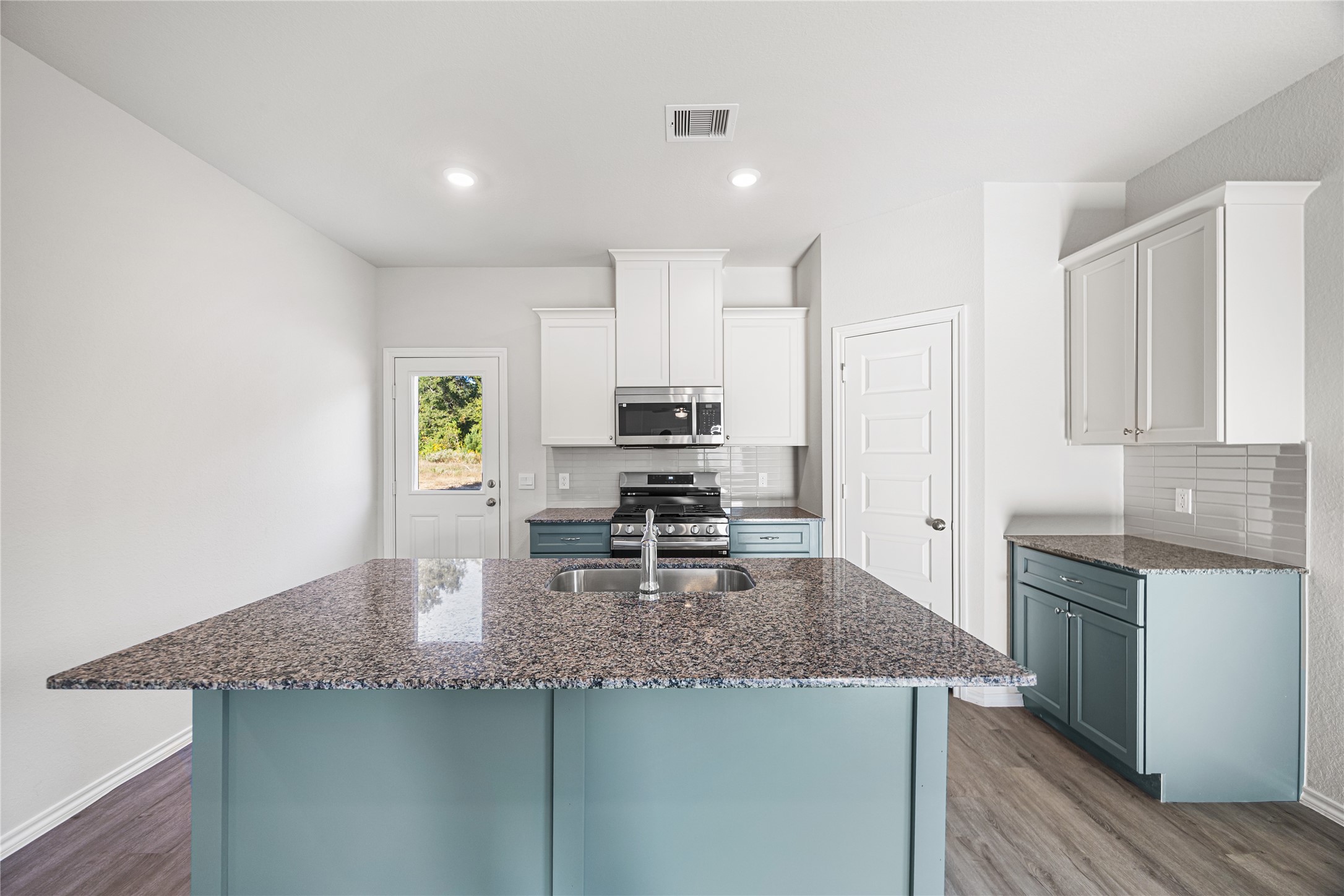 25799 John Wayne Court Splendora, TX 77372 - Photo 9 of 28 a kitchen with kitchen island granite countertop a sink appliances and cabinets