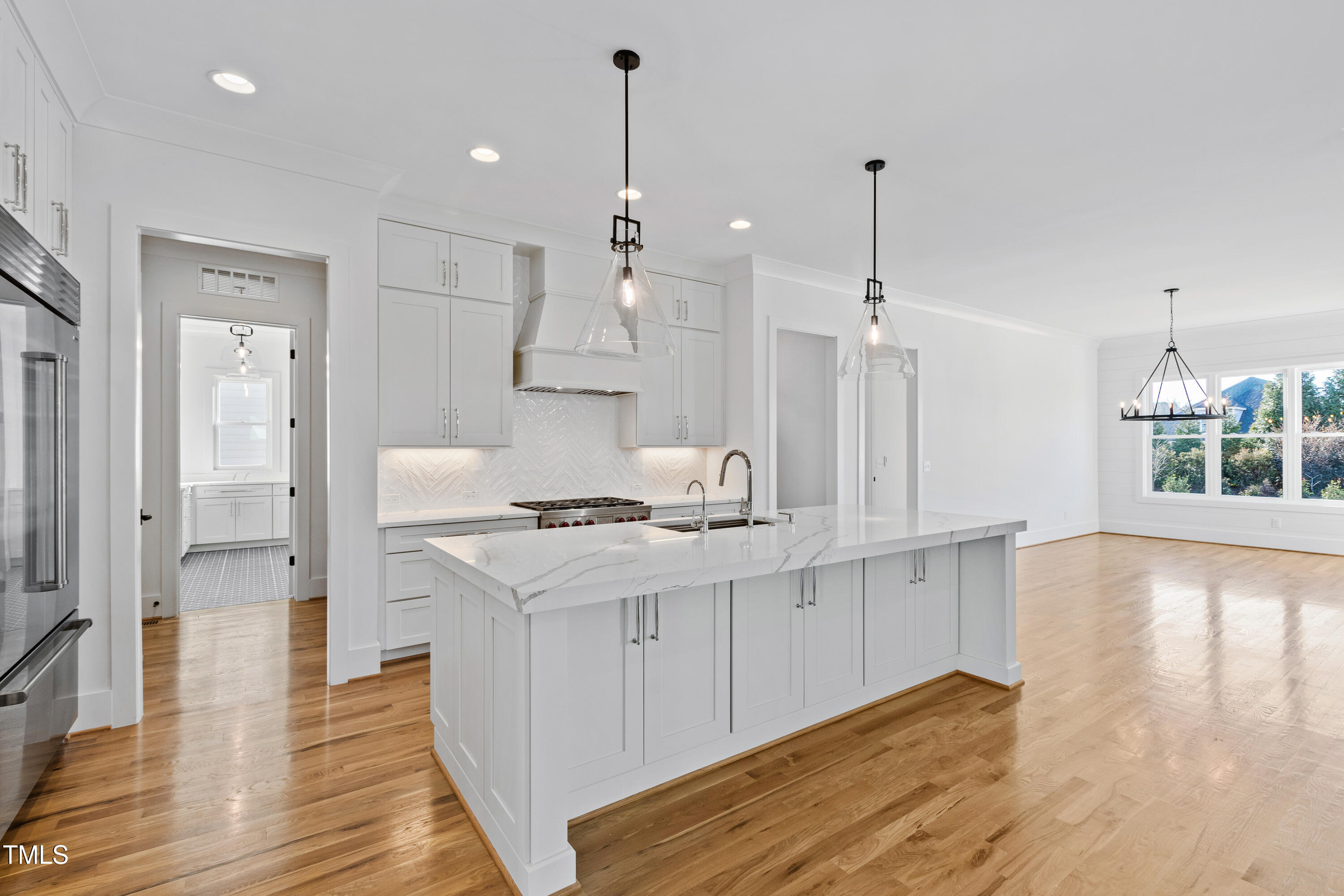 920 Lily Claire Lane Fuquay-Varina, NC 27526 - Photo 10 of 62 a kitchen with stainless steel appliances granite countertop a sink a stove a refrigerator and a wooden floor