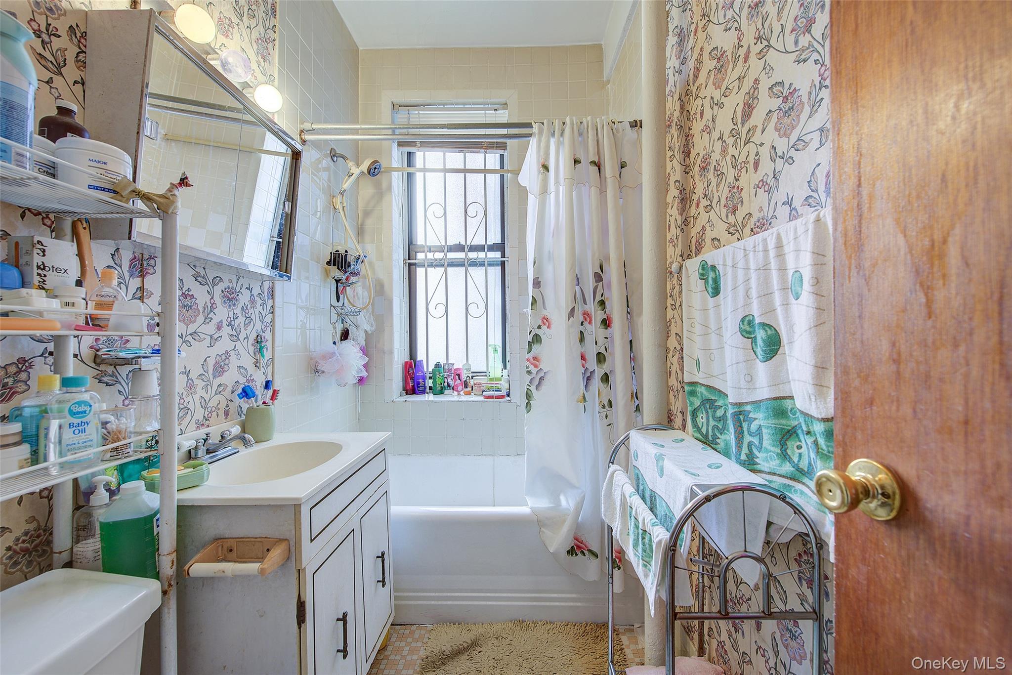 41-41 41st Street, Unit 1G Queens, NY 11104 - Photo 15 of 29 a bathroom with a sink a toilet and shower curtain