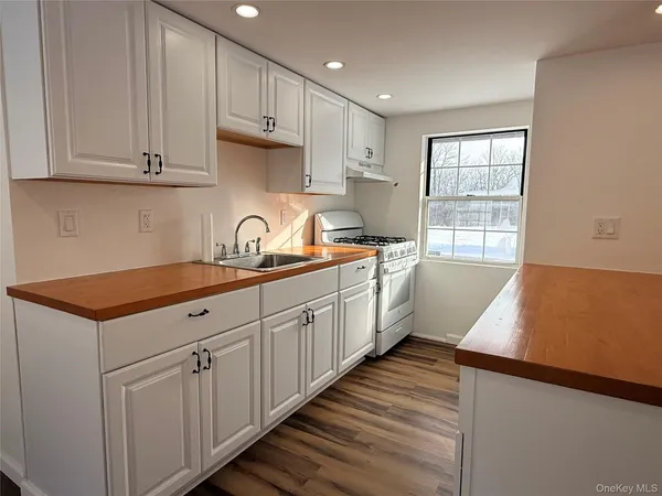 a kitchen with granite countertop white cabinets and white appliances