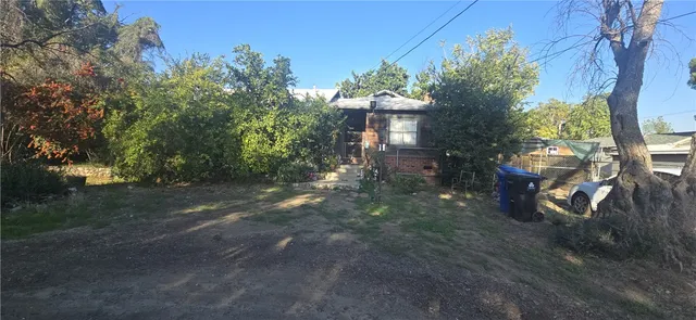 a view of a house with a yard and tree s